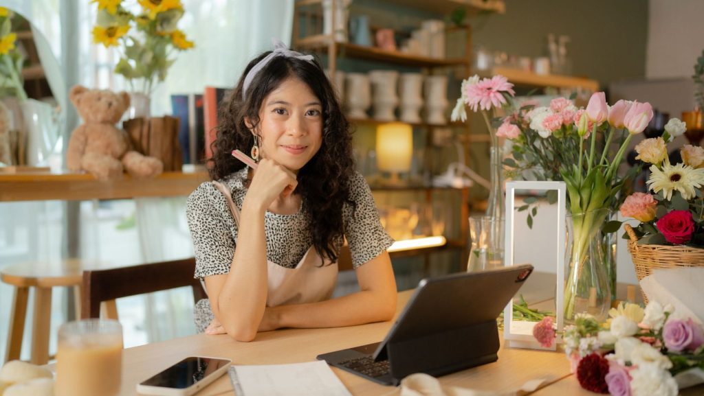 A florist strategizing behind a counter in a flower shop