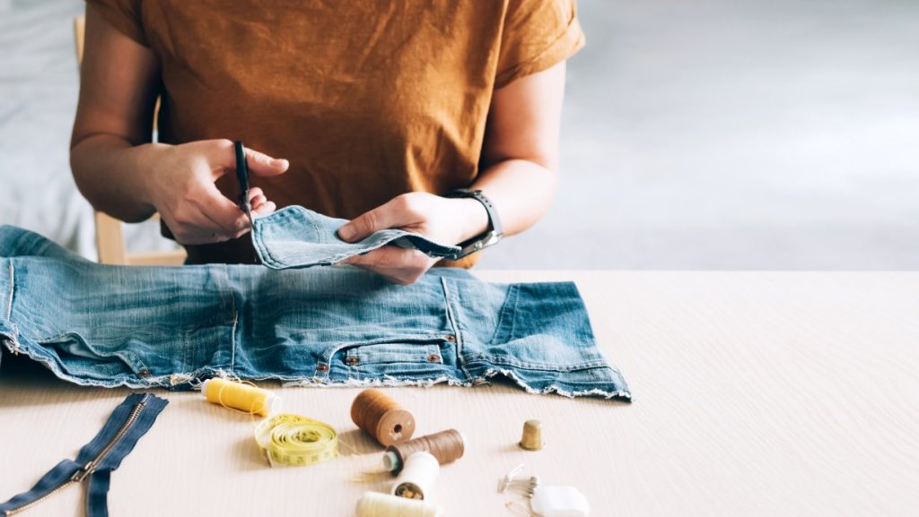 A woman repurposing an old pair of jeans