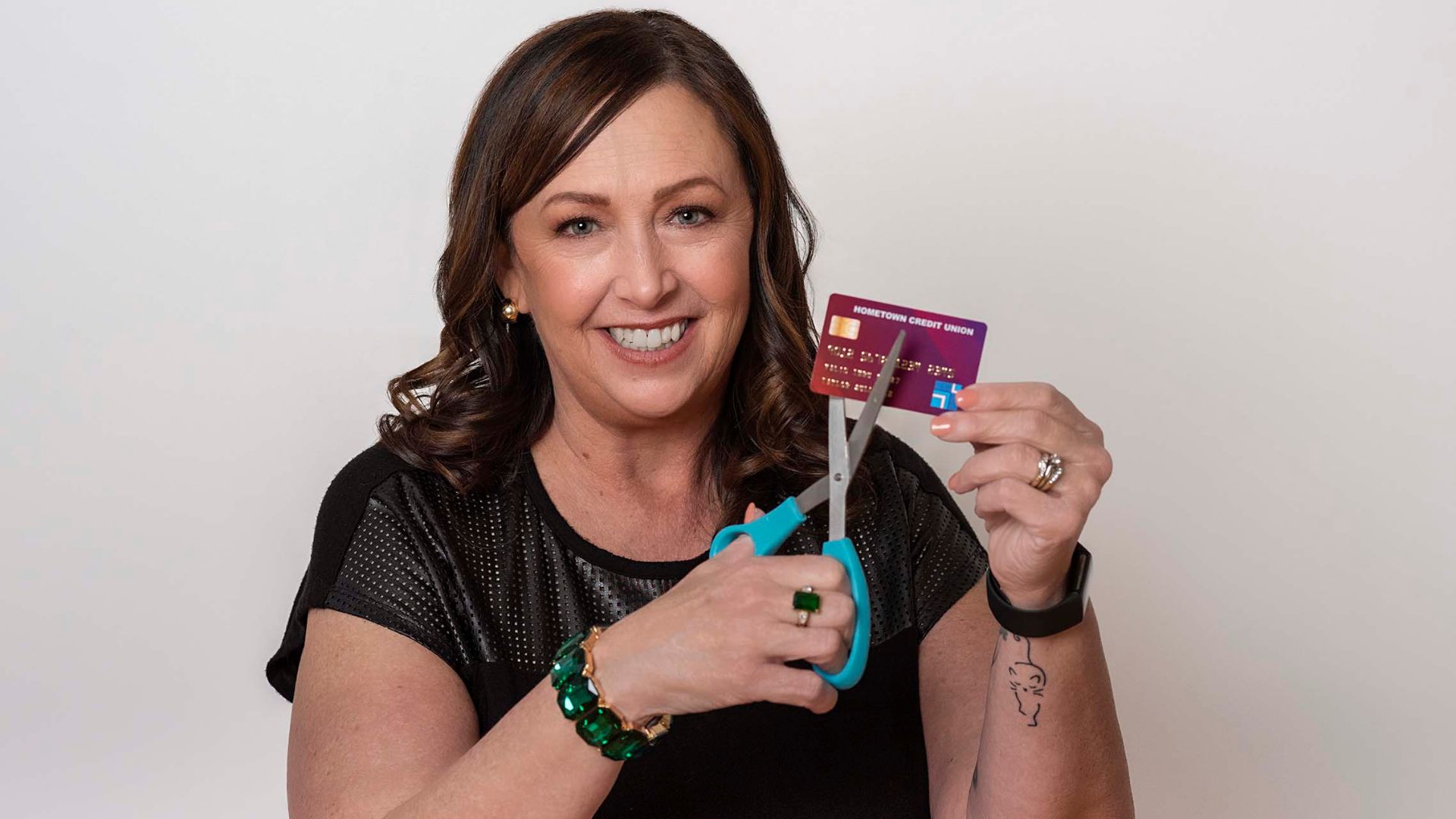 A financial coach cuts up a credit card to demonstrate taking control of finances