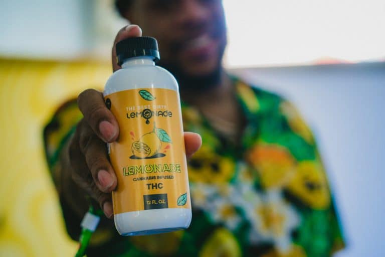 An exhibitor holds up a THC product at Flower Expo.