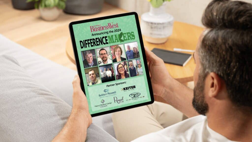 A man looks at the Difference Makers 2024 publication on a tablet.