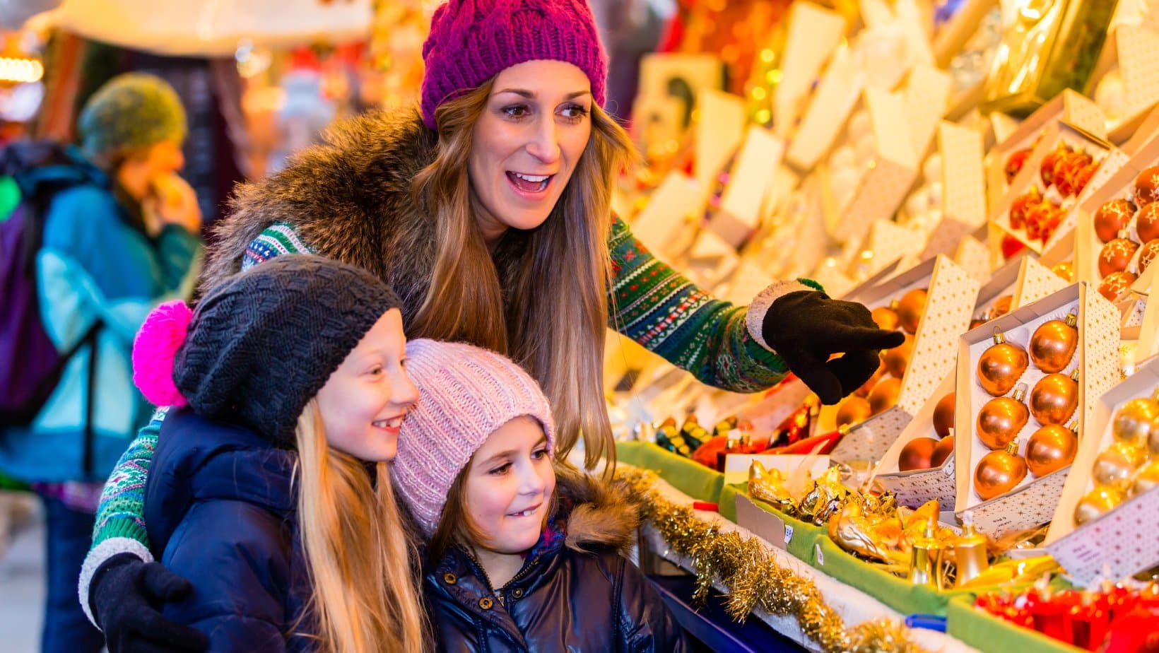 A woman and two children at a holiday market.