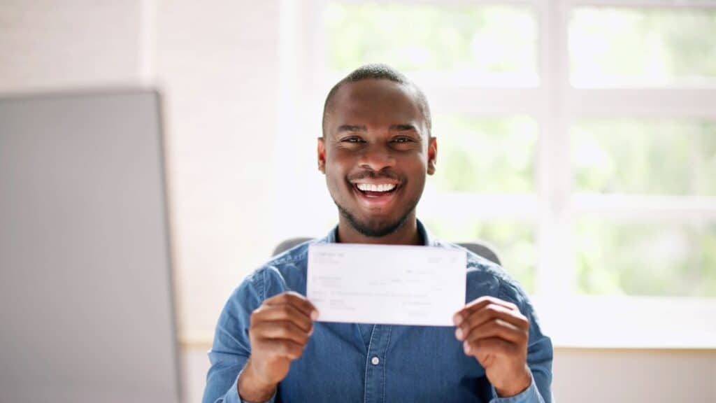A man happily smiling at being eligible for a grant.