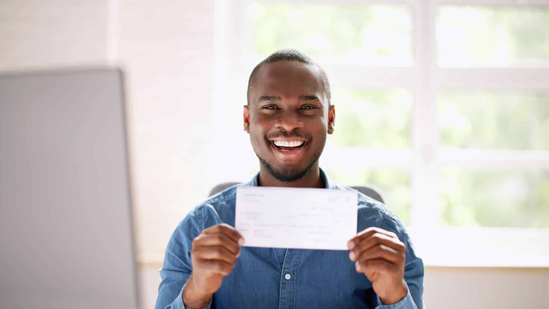 A man happily smiling at being eligible for a grant.