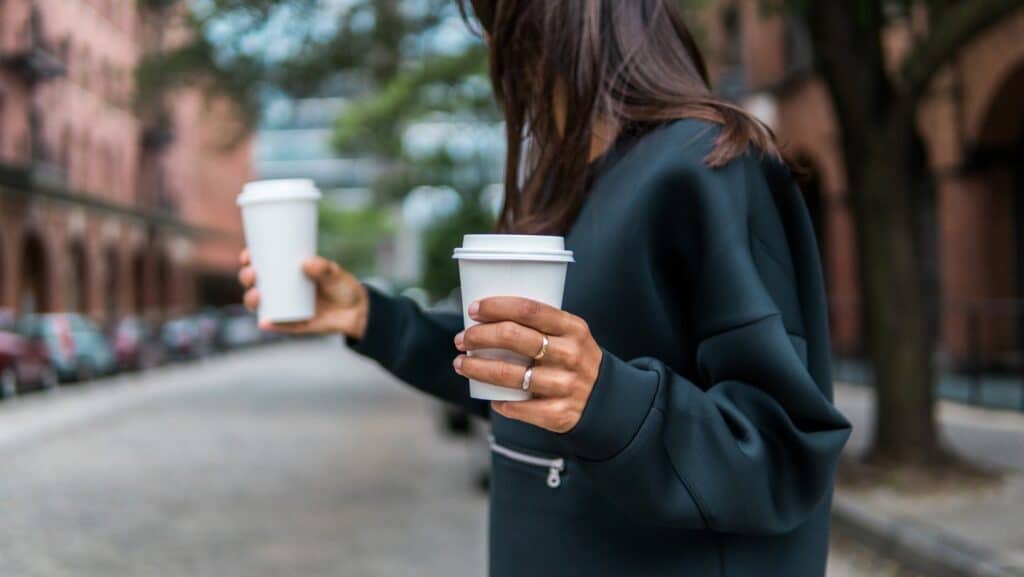A woman with two to-go coffee cups.