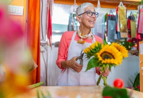 Flower shop owner happily smiling to her customers.