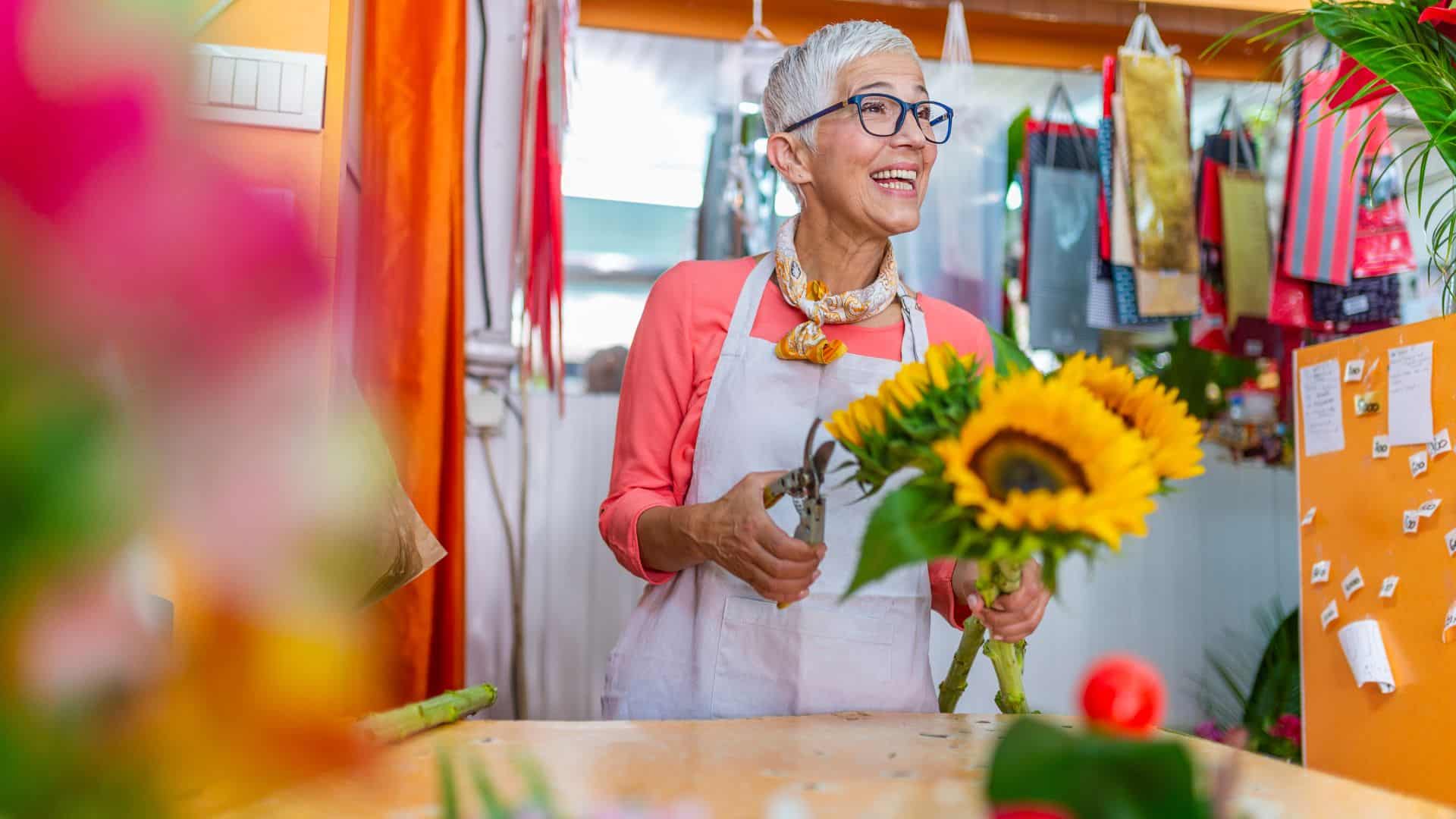 Flower shop owner happily smiling to her customers.