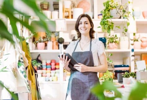 Small business owner smiling for the picture while doing her inventory.